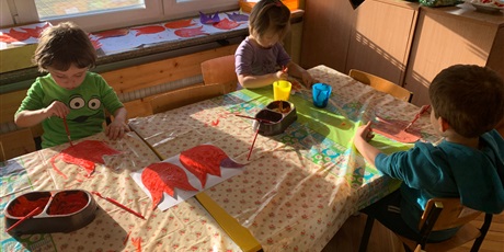 Powiększ grafikę: Trójka dzieci siedzi przy stole. Malują farbami