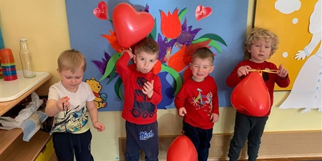Powiększ grafikę: Czwórka chłopców trzyma czerwone balony w kształcie serca