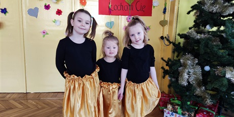 Powiększ grafikę: Trzy dziewczynki w złotych spódnicach uśmiechają się