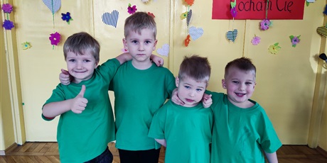 Powiększ grafikę: Chłopcy w zielonych koszulkach obejmują się. Pozują do zdjecia