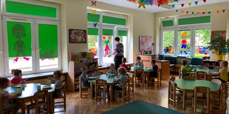 Powiększ grafikę: Sala przedszkolna. Dzieci siedzą przy stolikach i spożywają posiłek