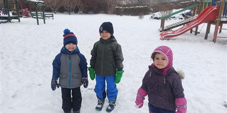 Powiększ grafikę: Trójka dzieci ubrana w zimowe urbania uśmiecha się