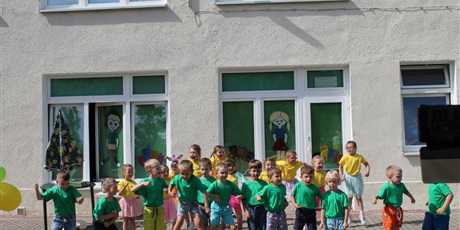 Powiększ grafikę: Na pierwszym planie znajduje się grupa dzieci w zielonych koszulkach. Za nimi stoi grupa dzieci w żółtych koszulkach