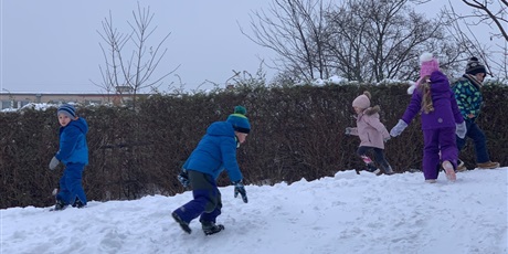 Powiększ grafikę: Piątka dzieci biega po śniegu