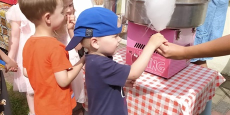Powiększ grafikę: Chłopiec w niebieskiej czapce otrzymuje watę cukrową